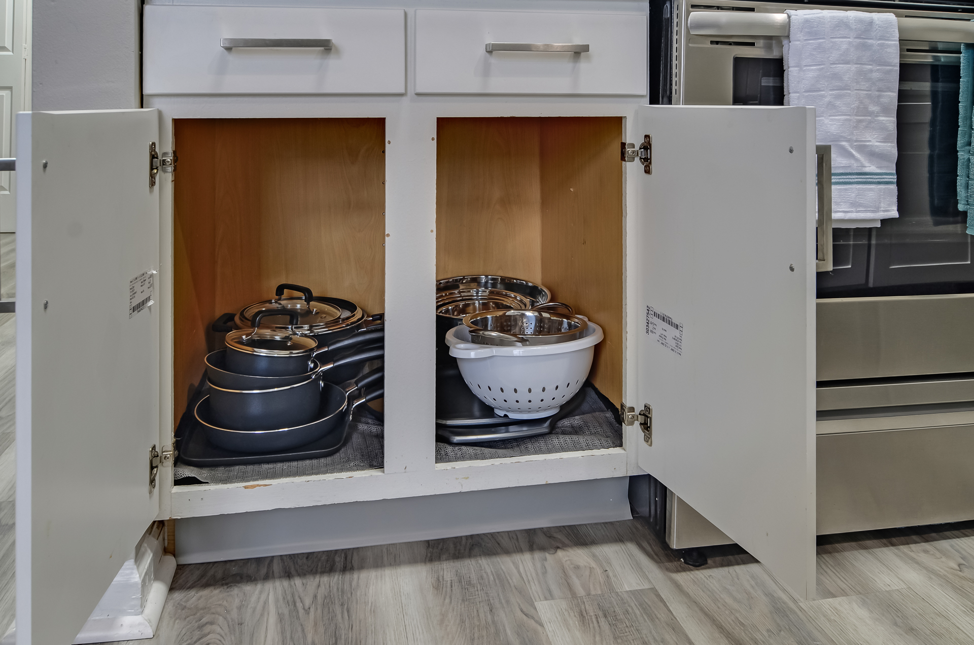 fully stocked kitchen cabinets with pots and pans